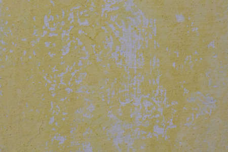 Yellow and Gray Dirty Plaster Wall, With Falling Off Flakes Of Paint. Rough Surface. Peeled Plasterの写真素材