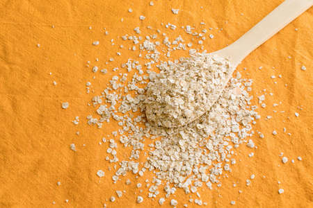 Spoons with raw oatmeal on Wooden Spoon on Linen Fabricの写真素材