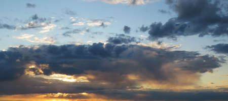 Beautiful colored sunset in the sky with dark clouds, natural background