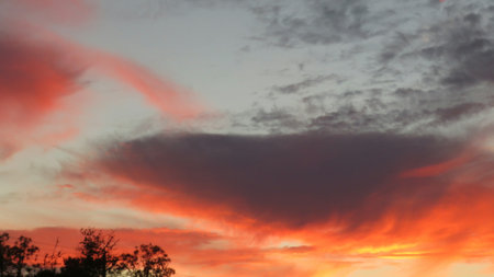 Fiery sunset background with dark clouds in the sky