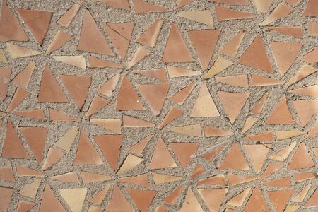 Background of orange mosaics on grey plaster.の写真素材