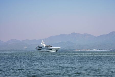 Sailboat in the sea in the morning light on the background of beautiful big mountains,y