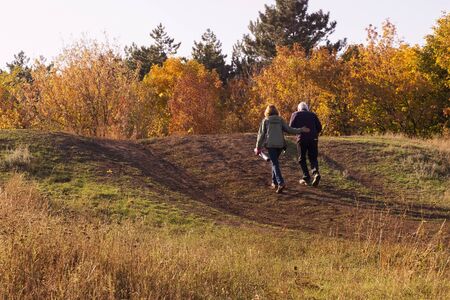 An elderly couple on a walk in the autumn forest. Healthy lifestyle in retirement age.の写真素材