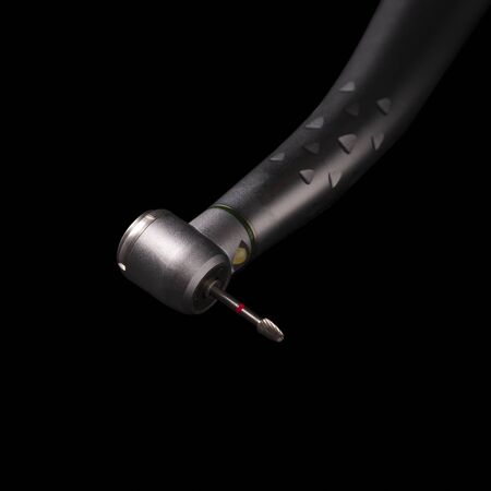 Stainless steel high speed dental hand parts with tiny grinding wheel isolate on black backgroundの写真素材