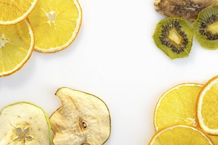 Dry fruit slices of orange kiwi apples on white background space for textの写真素材