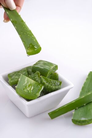 Aloe Vera leaf for making cosmetics.A drop falls into Cup with slices of aloe Veraの写真素材