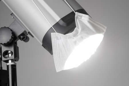 Studio Lighting Device with medical face mask. Concept of protection from coronavirusの写真素材