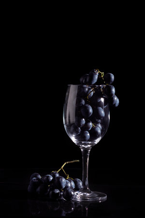 The concept of fresh, natural wine, juice from grapes. A bunch of grapes in wine glass.の写真素材