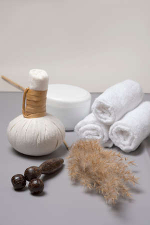Spa composition of herbal massage bags, a jar of oil and a hand-held wooden massagerの写真素材