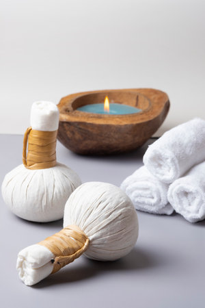 Spa composition of a herbal ball massage, towel with a candleの写真素材