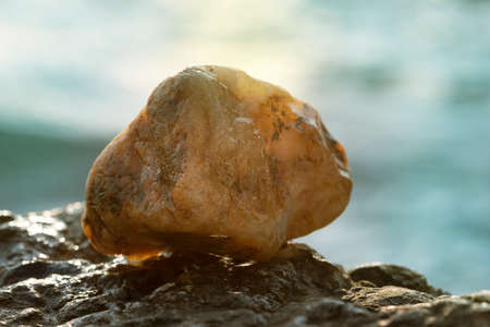 Golden stone on the background of a sea sunset.の写真素材