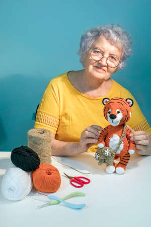 Cheerful old woman Handmade knitted toys. Amigurumi toys. Crochet stuffed animal tiger.の写真素材