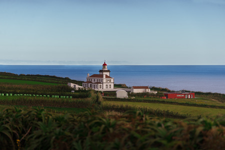 The lighthouse standing on the shore of the Atlantic Ocean and showing the way for the shipsの写真素材