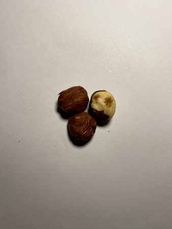 Peeled hazelnuts lie in a pile on a white background. Healthy and delicious