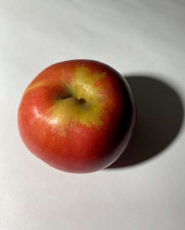Red apple on a white background. The shadow of the apple.