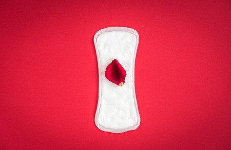 Woman hygiene protection on red background. Small and big sanitary pads.の写真素材