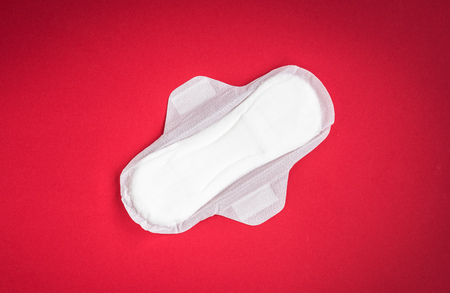 Woman hygiene protection on red background. Small and big sanitary pads.の写真素材