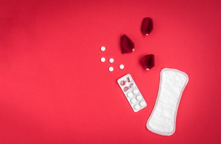 Woman hygiene protection on red background. Small and big sanitary pads.の写真素材
