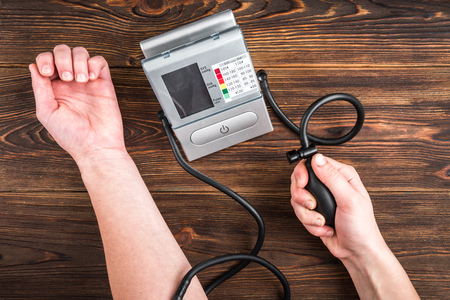 Electronic medical tonometer for measuring blood pressure on wooden tableの写真素材