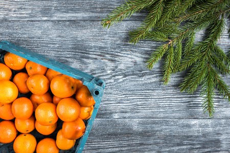 Mandarines on wooden background with Christmas fir branches, cinnamon sticks, anise stars and cones.の写真素材