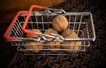 walnuts in shells lie in a shopping basket , shopping cartの写真素材