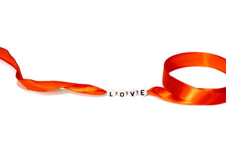 word love made of beads on a red ribbon, isolate on white.の写真素材
