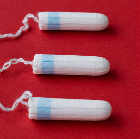 sanitary tampon made of cotton and other materials, close-up on a redの写真素材
