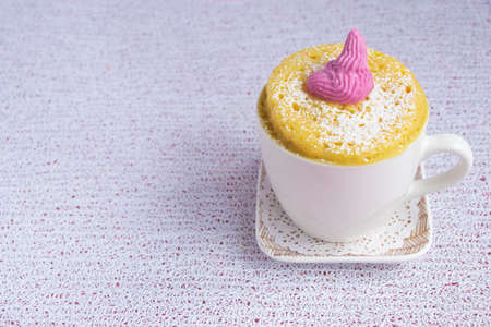 cupcake in a mug cooked in the microwave. White cup on a square small plate.の写真素材
