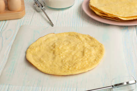 cake layers on baking parchment. The base of the cake on a wooden table.