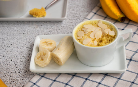 cupcake in a mug with banana pieces. Banana cupcake on a light background.の写真素材