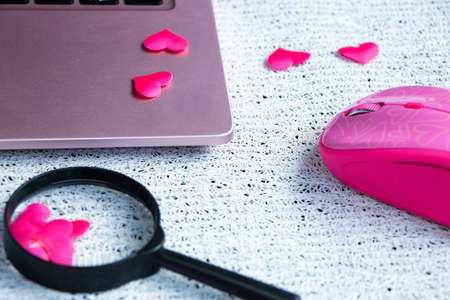 Red heart on the computer keyboard, magnifying glass with handle.の写真素材