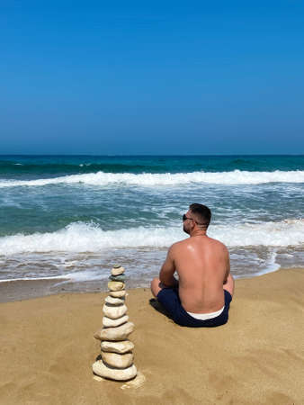 the guy sits near the tower with stones and looks into the horizon.の写真素材