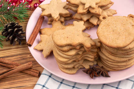 full plate of homemade freshly made gingerbread cookies on wooden background.