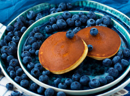 selective focus. pancakes with blueberries on a blue plate.