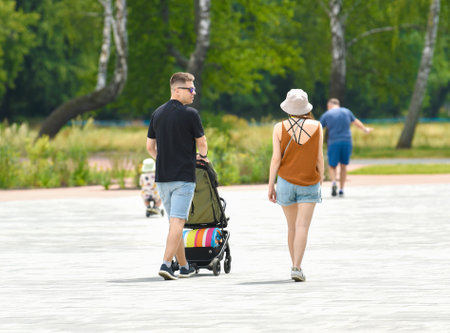 Happy parents walking with their baby in stroller at park on sunny dayの写真素材
