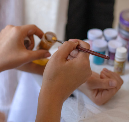 Kids animator is creating a Shimmering sparkling glitter tattoo . Body artの写真素材