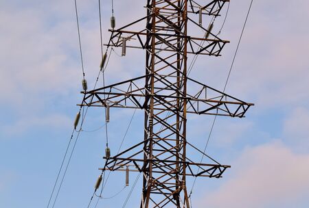 Metal support for high voltage power lines against the sky. Electrical cables are attached to the pylon on poles through glass insulators. Power lines, power supply concept.の写真素材