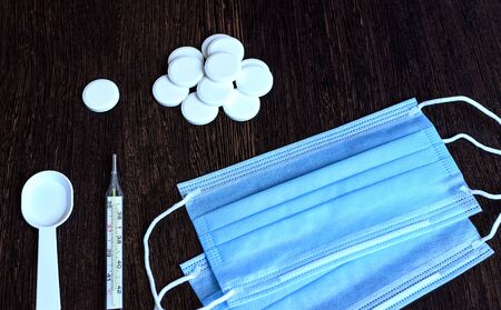 Medication on a dark background. Thermometer, pills, medical mask.の写真素材