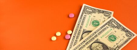American dollar and colored pills on orangeの写真素材