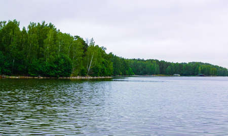 Lake Uvildy, Southern Urals (Chelyabinsk region, Russia). Big lake forest landscape. Sun glare on the water surface. Selective focus.の写真素材