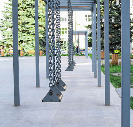 Modern swing on city streets. Resting place in the city. City landscape.の写真素材