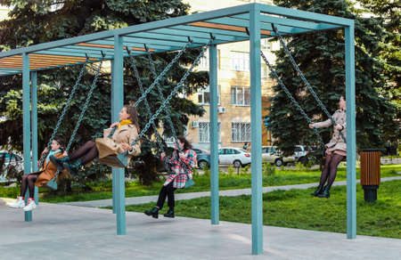 Russia, Chelyabinsk, October 04, 2020: Young happy women ride on a swing. Resting place, riding on a...