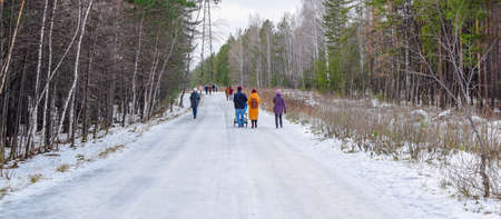 Russia, Chelyabinsk, November 01, 2020. Walk in the winter forest. People walk along a wide forest...