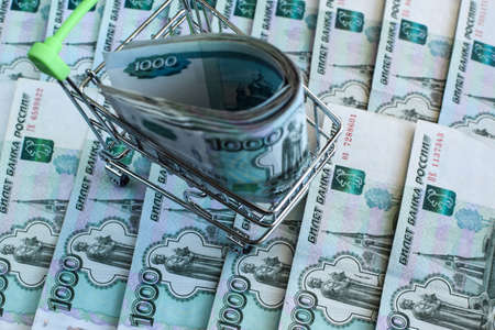 Russian rubles in the basket for products. Blurred background of money. Cart for groceries on the...