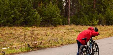 Boy is tired and resting after cycling. Autumn forest landscape, cycling.