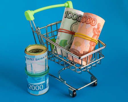 Russian rubles in a grocery basket on a blue background. Financial crisis, ruble devaluation...