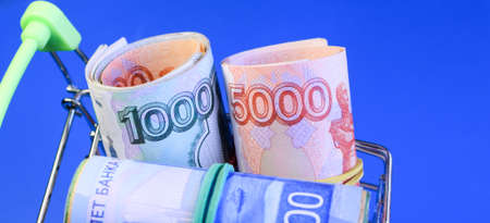 Russian rubles in a grocery basket on a blue background. Financial crisis, ruble devaluation...
