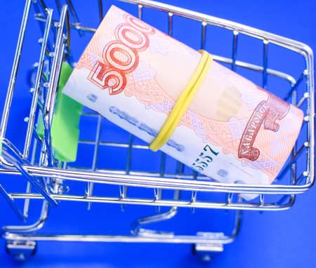 Russian rubles in a grocery basket on a blue background. Financial crisis, ruble devaluation concept. Selective focus.の写真素材