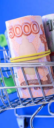 Russian rubles rolled into a tube on a blue background. Banknotes tied with an elastic band....