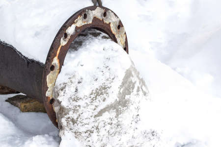 Frozen water in a wide pipe in winter. Communal accident. Copy space for text.の写真素材